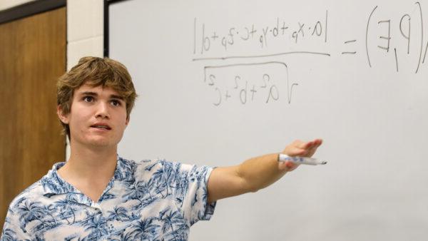 Student with math problem at whiteboard